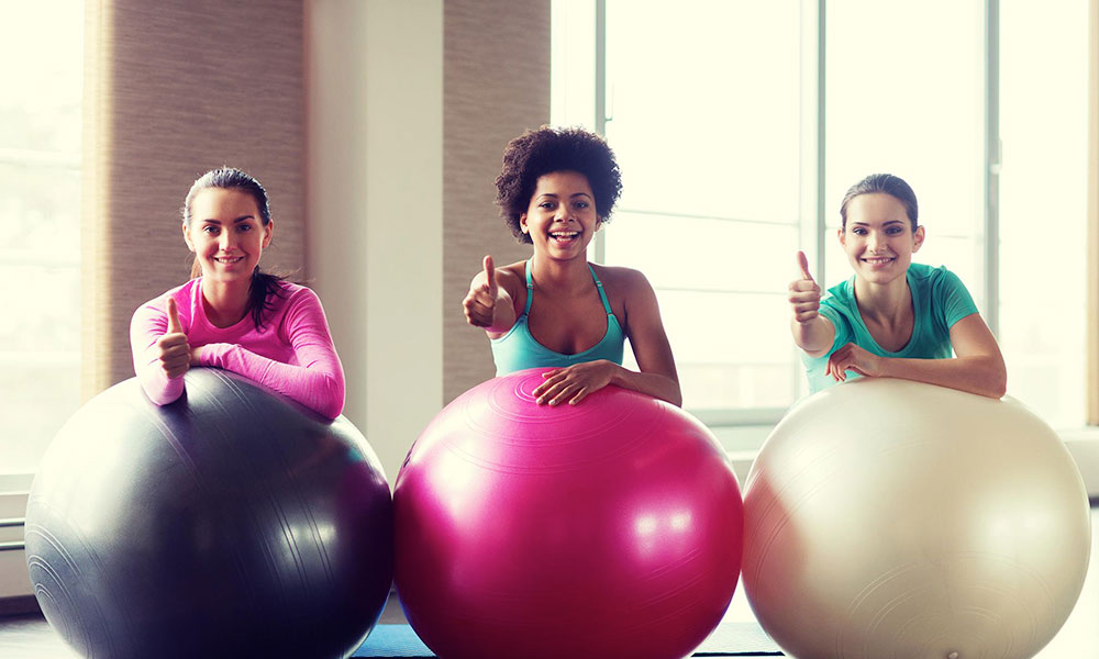 women doing physio stretches on exercise ball